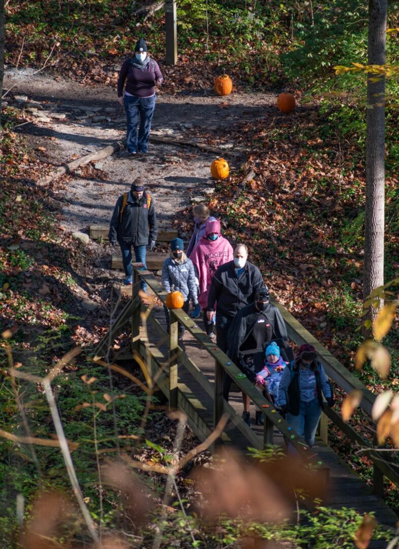 Family with Luke5Adventures crossing a bridge at the be.well Halloween Hike