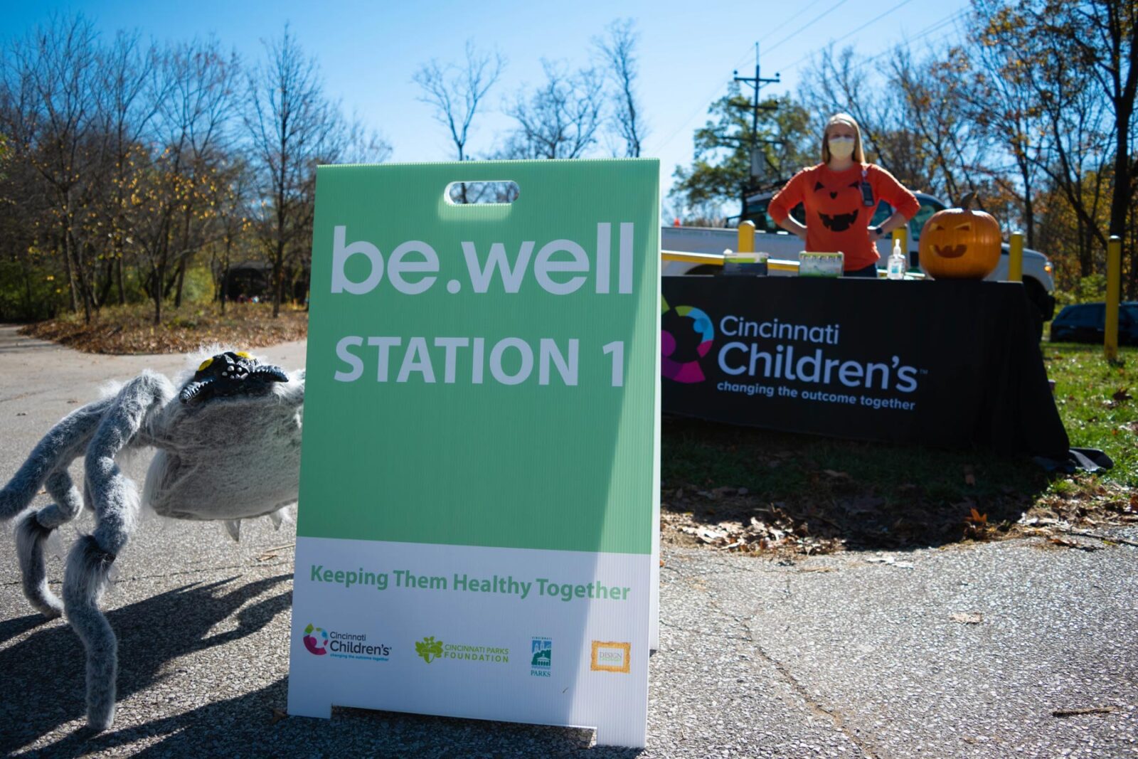 A woman dressed as a pumpkin at the Cincinnati Children's booth at the be.well Halloween Hike