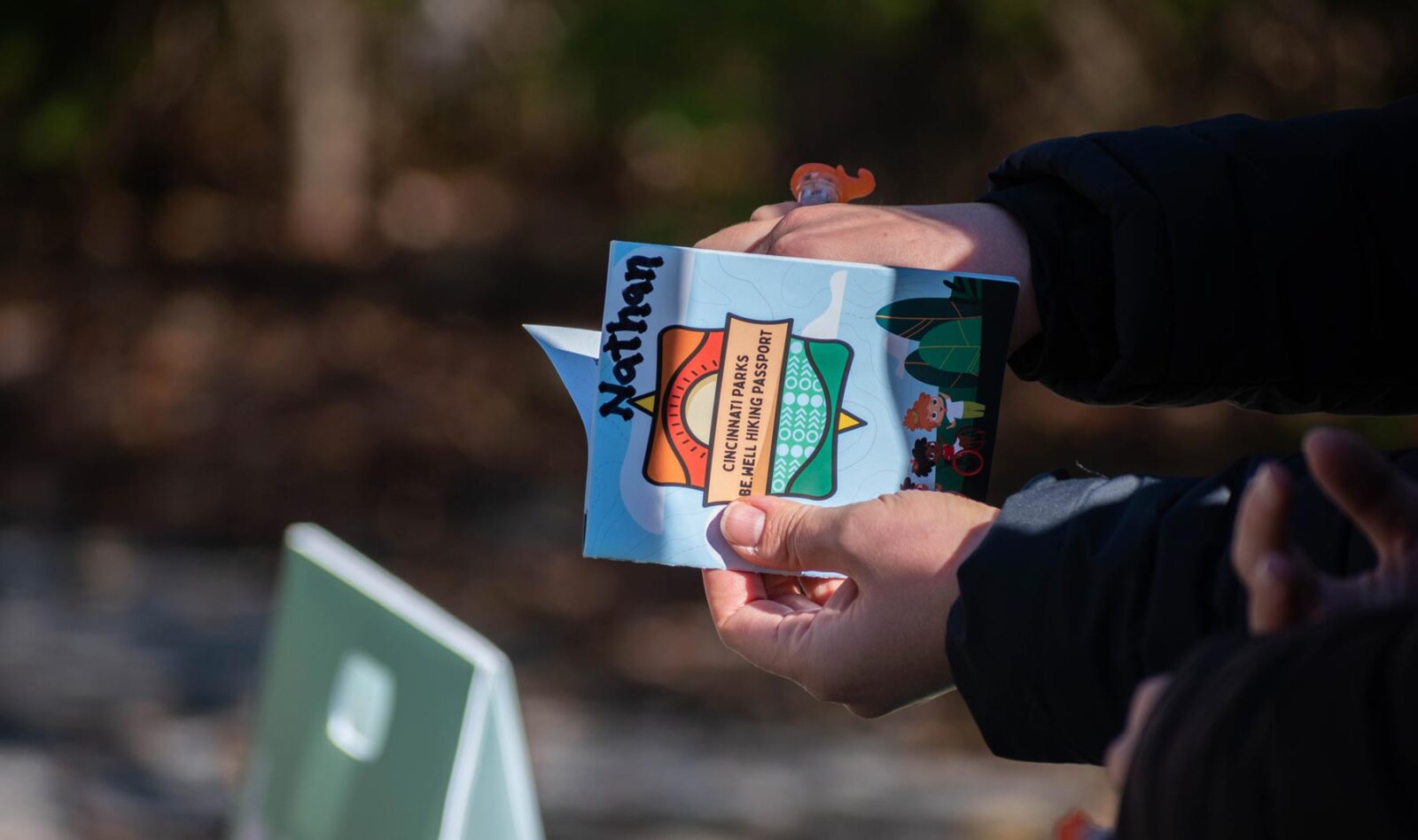 Someone holding the be.well Fall Adaptive Hiking Program booklet