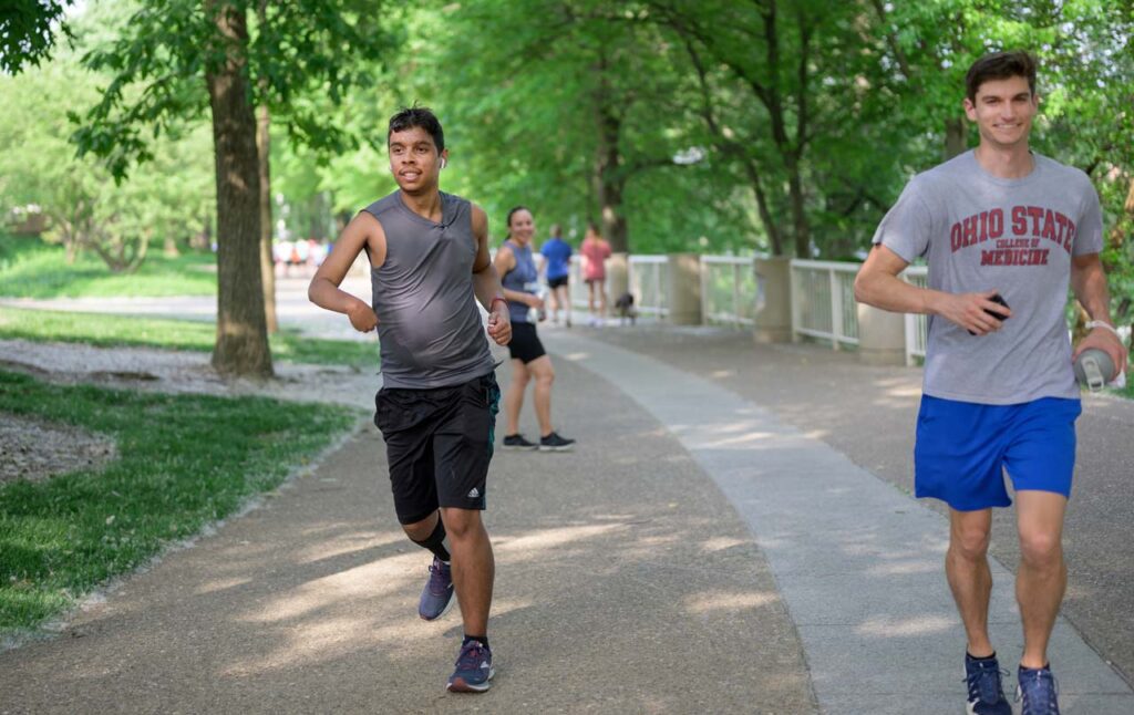 An athlete with disabilities runs through a Cincinnati Park in the be.well program.
