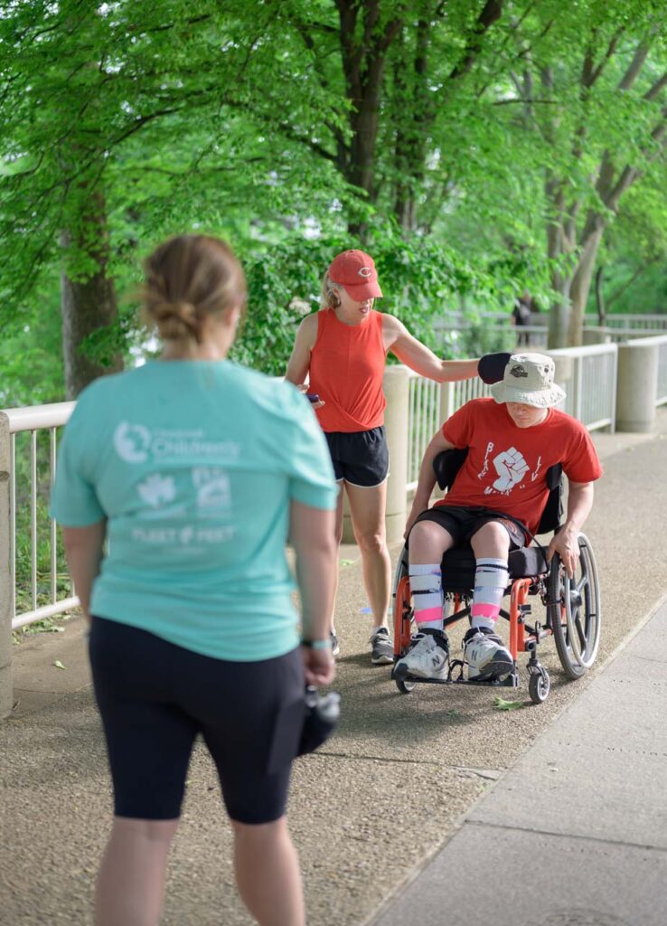 Fleet Feet's Coach Katie cheers on an athlete who uses a wheelchair.