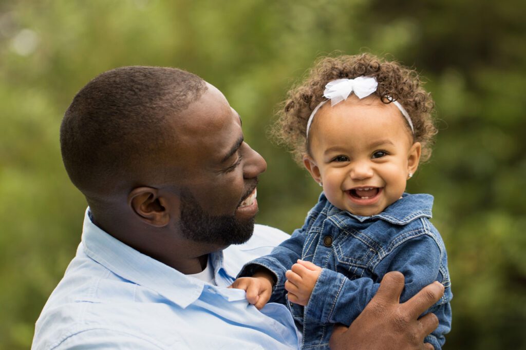 A father holds a toddler in a Cincinnati park.