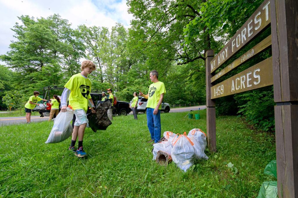 Piles of litter in trash bags by the Mt. Airy Sign