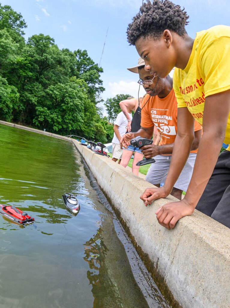 Stephan Pryor teaching children how to use RC boats in Eden Park.