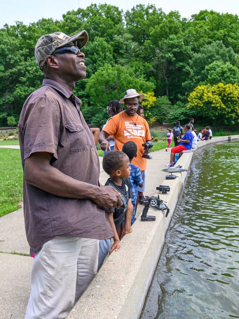 Former State Representative Dale Mallory teaching children how to use RC boats in Eden Park.