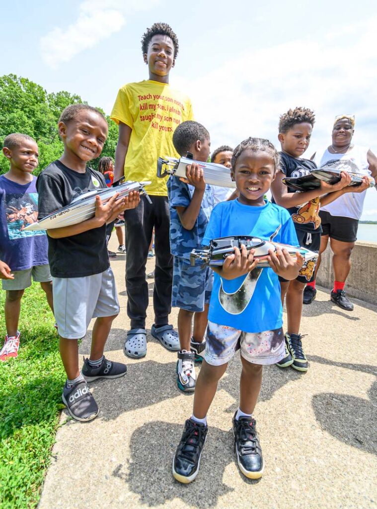 Children in the Reach a Youth Teach a Youth event in Eden Park holding boats purchased by Cincinnati Parks Foundation